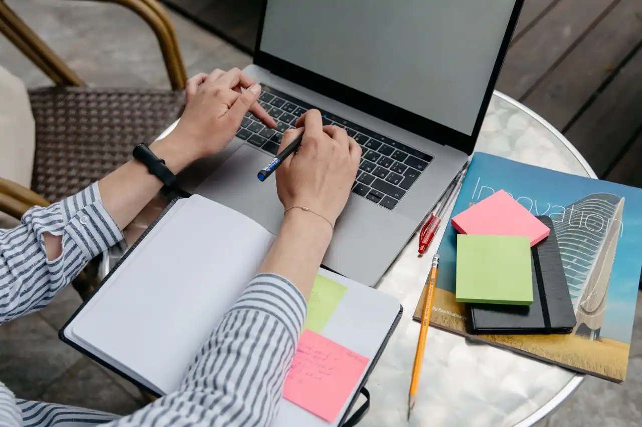 Organización de una actividad con laptop, cuaderno y notas adhesivas